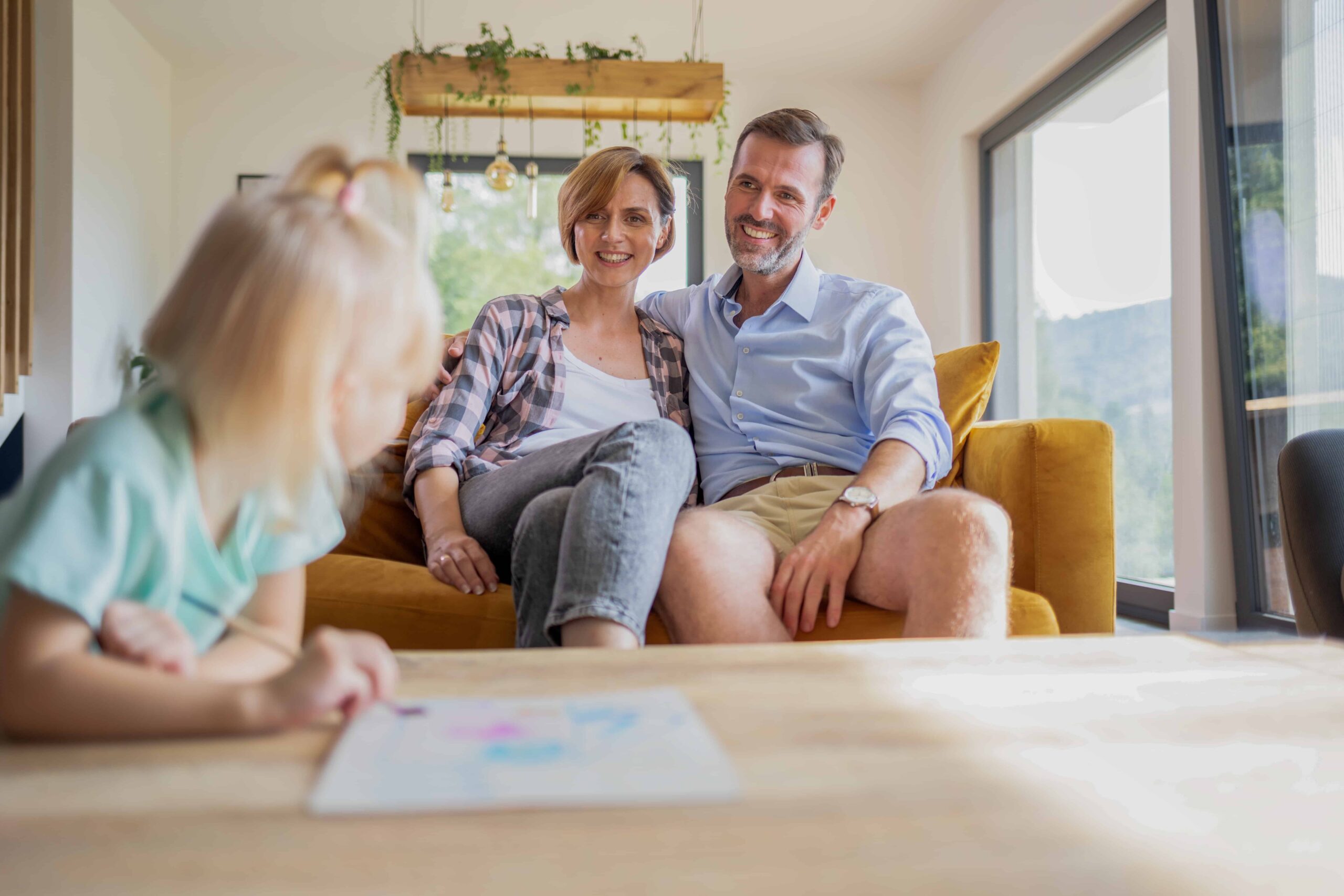 A family sitting on a couch in their home.
